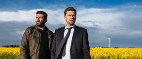 Two men in a field dressed in suits
