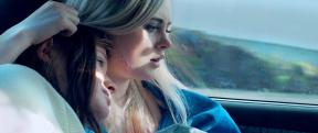 A comforting image of a women leaning on the shoulder of her friend. 
